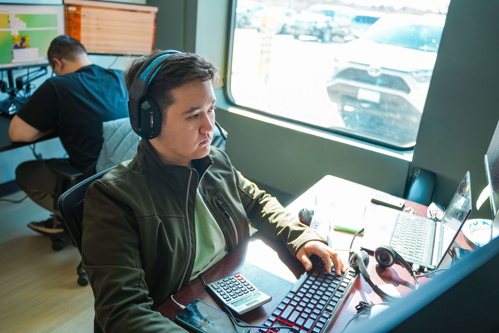 KGZ Transport dispatcher wearing headset and working on multiple monitors in the operations center